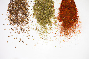 Close-up dried spices, tossed on a white background.