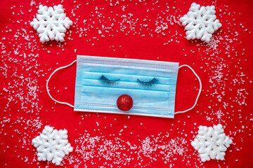 Coronavirus festive winter background mask with eyes, snowflakes, snow. The concept of a pandemic during the Christmas holidays.