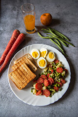 View from top of healthy food ingredients boiled vegetables, eggs and bread on a plate 