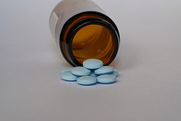 Glass bottle with blue pills.