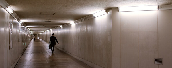 Silhouette of business man walking in dark underground...