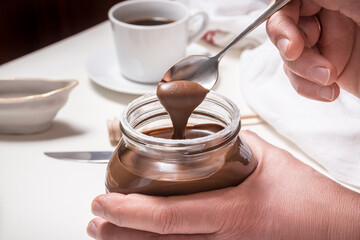 Hands opening bottle of chocolate butter