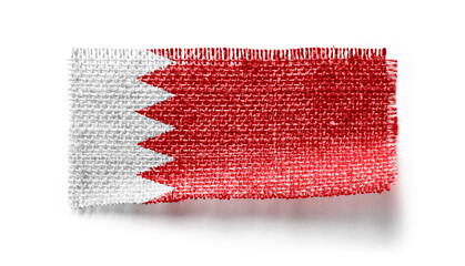 Bahrain flag on a piece of cloth on a white background