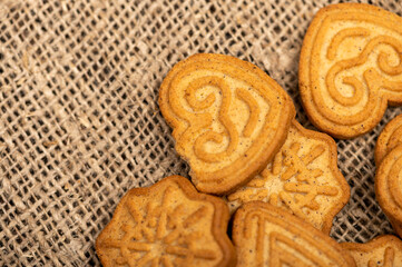 Delicious homemade cookies on a wooden table on a homespun fabric with a rough texture. Close-up selective focus.