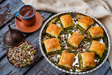 Baklava with pistachio in the plates with coffee