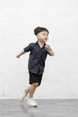 Studio shot portrait of happy little Asian boy on background