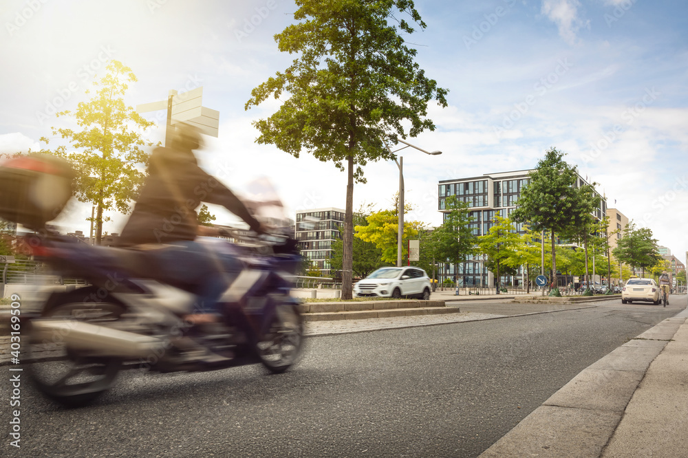 Poster Urban street with a motorcycle driving by