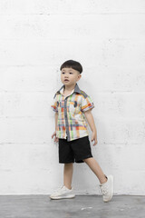 Studio shot portrait of happy little Asian boy on background