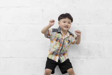 Studio shot portrait of happy little Asian boy on background