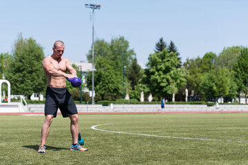 Man Exercising With Kettle Bell Outdoors