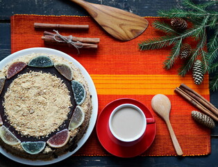 Rustic food background. Homemade layered honey cake with a cup of coffee and honey on a bright red napkin on a dark background.