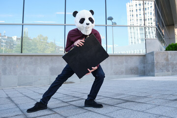 Male robber wearing a panda head mask stealing a briefcase escaping. Bizarre thief.