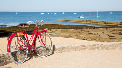 Bord de mer en France, vieux vélo rouge à la plage.