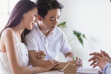 Young couple make contract for new house or apartment with agency