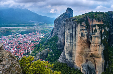 Fototapeta na wymiar View from cliff top over Kalambaka and Kastraki villages at foot of Meteora mountains, Greece, and famous impressive pillars around it on cloudy day