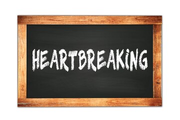 HEARTBREAKING text written on wooden frame school blackboard.