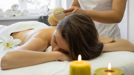 Obraz na płótnie Canvas Vietnamese massage with herbal compresses at the beauty shop