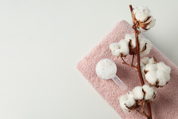Scoop with washing powder, cotton and towel on white background