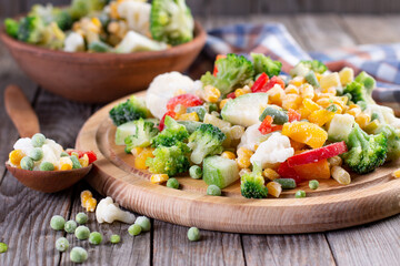 Frozen vegetables on wooden board on table