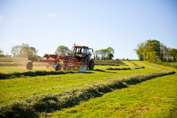 Tracteur faisant les foins en campagne au printemps.