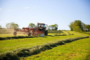 Fototapeta premium Tracteur faisant les foins en campagne au printemps.