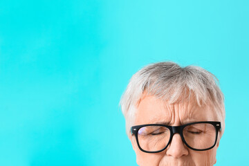 Stressed senior woman on color background