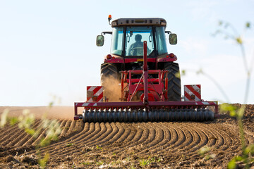Tracteur au travail et retournant la terre dans les champs.