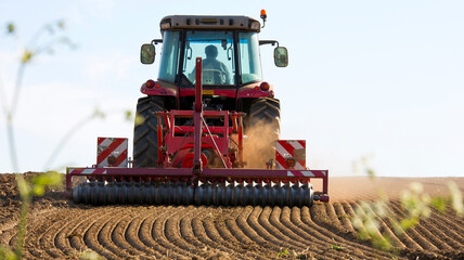 Obraz premium Agriculteur au volant de son tracteur au travail dans les champs.