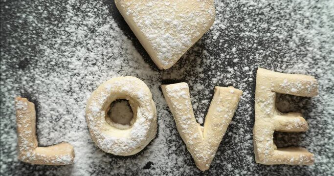 on a stone background, the letters from the dough in the form of the word love disappear in turn.