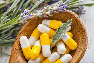 Wooden spoon with plant based pills on light background