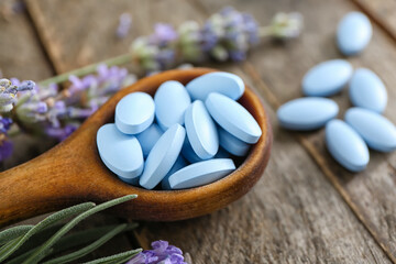 Spoon with plant based pills on wooden background