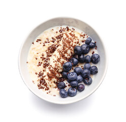 Bowl with tasty oatmeal and blueberry on white background