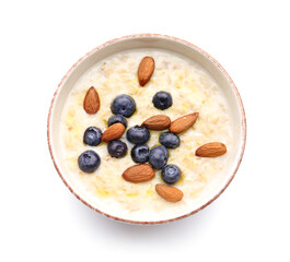 Bowl with tasty oatmeal and blueberry on white background