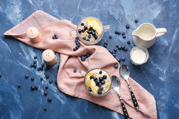 Bowl with tasty oatmeal and blueberry on color table