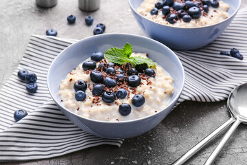 Bowl with tasty oatmeal and blueberry on table