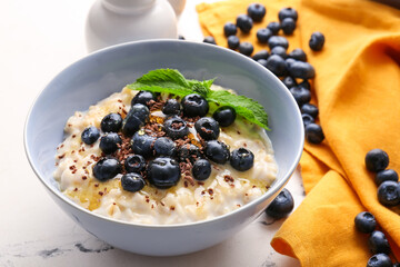 Bowl with tasty oatmeal and blueberry on table