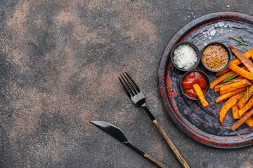 Board with tasty cooked sweet potato on grunge background