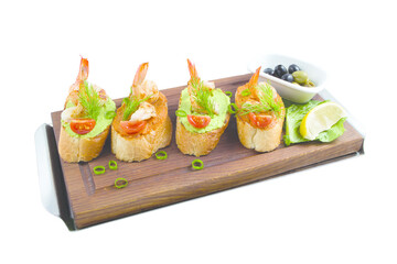 Canapes with avocado and squash caviar and garlic shrimps on crispy bread. A simple and light snack for parties and banquets. Restaurant serving concept.