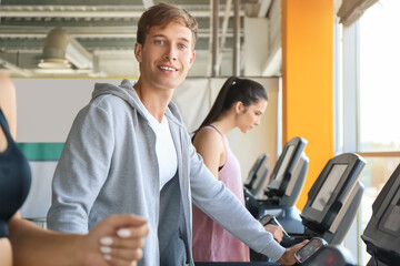 Fototapeta na wymiar Young people training on treadmills in gym