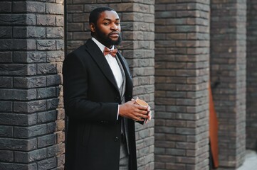 Fashion portrait of a handsome young African American business man walking outdoors in a casual pose.