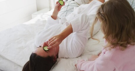 Caucasian mother and daughter having fun relaxing in bedroom - Powered by Adobe