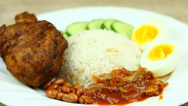Pouring anchovy sauce on Nasi lemak plate ), Malaysian famous food