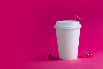 Two white cups for coffee and tea and glass hearts on a pink background. Mockup. Horizontal format. Copyspace