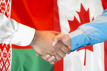 Business handshake on the background of two flags. Men handshake on the background of the Belarus and Canada flag. Support concept