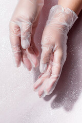woman hands wearing transparent disposable plastic glove on white background