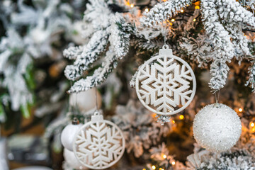 Closeup of a Christmas ball toy hanging from a decorated Christmas tree.