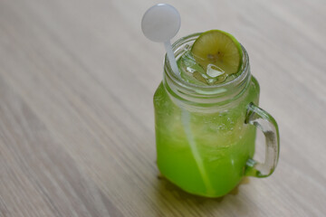 Kiwi Soda in a glass with sliced ​​lemon on top