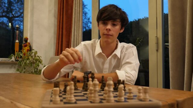Ragazzo concentrato che sposta una pedina su una scacchiera durante una partita a di scacchi
Primo piano sulla scacchiera con movimento laterale