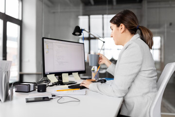 business, startup and people concept - businesswoman with computer and coffee working at office