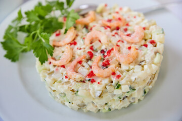 Salad of cucumbers, capers, quail eggs, beef tongue and shrimps in mayonnaise sauce. Close-up, selective focus